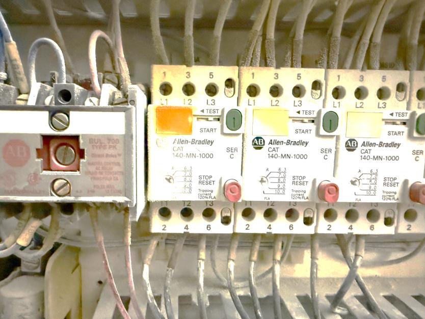 Allen-Bradley 140-MN-1000 motor starters in motor control center with orange indicator flags and terminal connections
