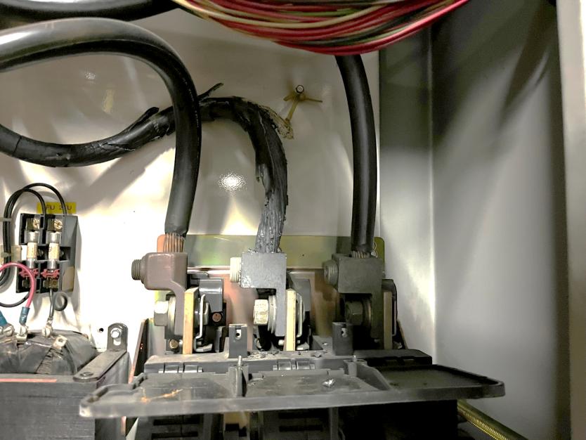Melted bus bar connection showing severe heat damage and melted cable insulation
