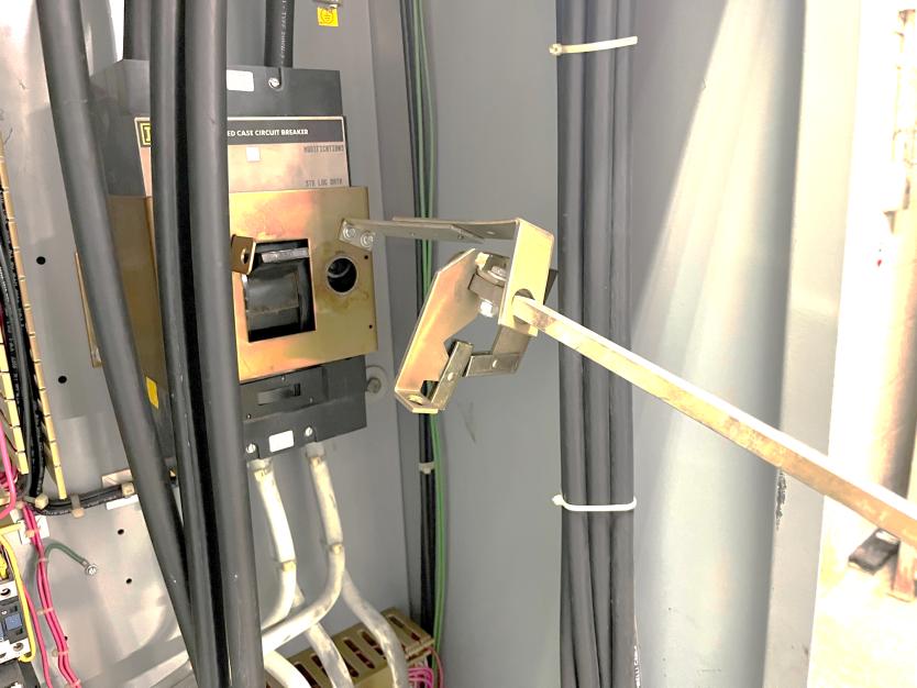 Technician using remote racking hot stick to operate circuit breaker from safe distance